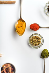 Colorful middle eastern spices in spoons on white background with copy space