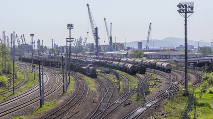 Fototapeta na wymiar rail rails and multi-wagon trains waiting for loading and departure. urban landscape of a railway station with many wagons and locomotives located next to a harbor.
