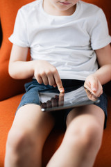 Obraz na płótnie Canvas A young boy playing games on his tablet