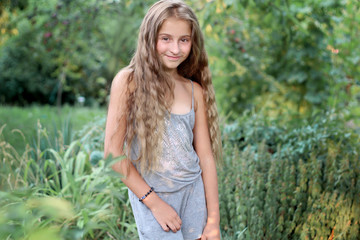 Close-up portrait of a teenage girl on a background of a green background on the nature