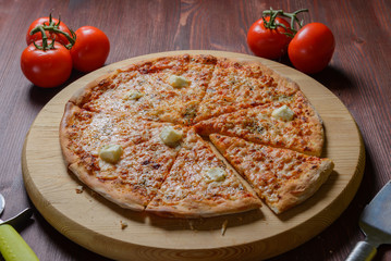 Pizza on wooden board sliced