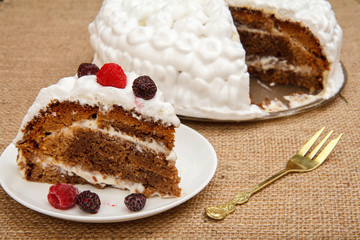 Sliced homemade biscuit cake decorated with whipped cream