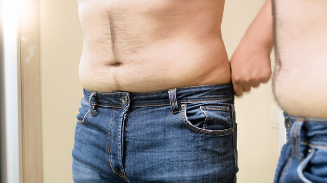 Closeup photo of young man with big hairy belly