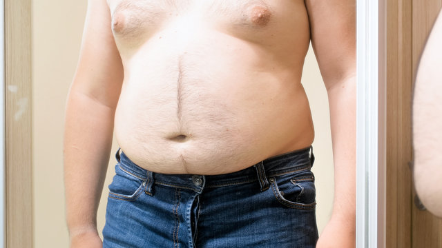 Shirtless man in jeans with big fat belly