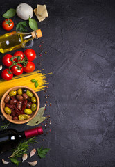 Selection of healthy food. Italian food background with spaghetti, wine, mozzarella parmesan cheese, olives, tomatoes and rosemary. Vegetarian food banner. overhead, vertical