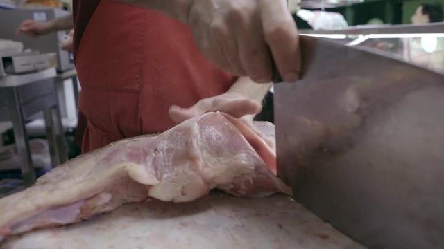 Butcher Cutting Raw Meat