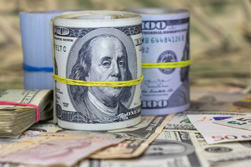 roll of cash against the background of other currencies
