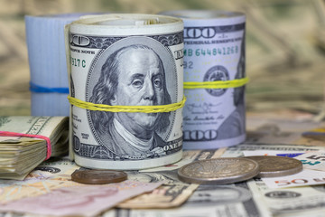 roll of cash against the background of other currencies