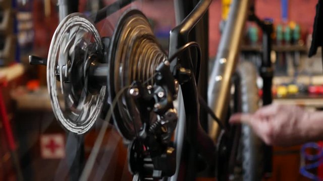 Mechanic repairing bicycle in workshop.
