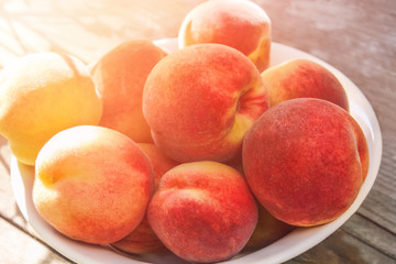 Ripe peaches in white bowl