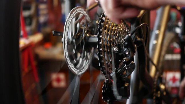 Mechanic repairing bicycle in workshop.