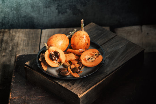 Eating fresh loquat fruit in rustic table