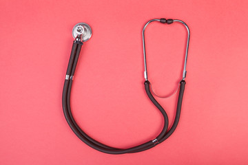 Stethoscope isolated on red background