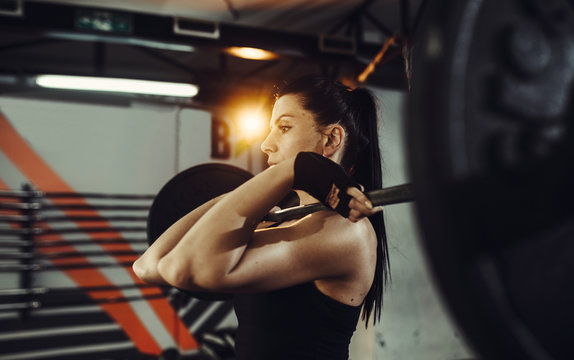 Fit woman lifting heavy weights. Fitness  female doing heavy weight workout at gym.