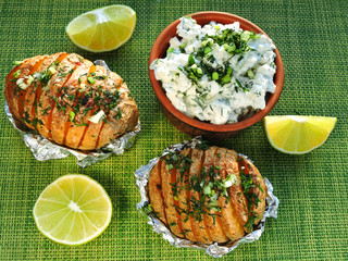 Potatoes baked in their skins with herbs and lime slices. Baked potatoes and lime.