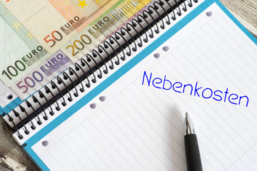 Nebenkosten für eine Wohnung, Euro Geldscheine und ein Schulheft