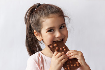 Cute child girl eating chocolate. Pretty child with chocolate.