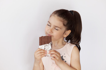 Cute child girl eating chocolate. Pretty child with chocolate.