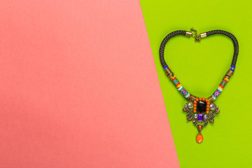 Bijou necklace on a bright bicolor background, top view