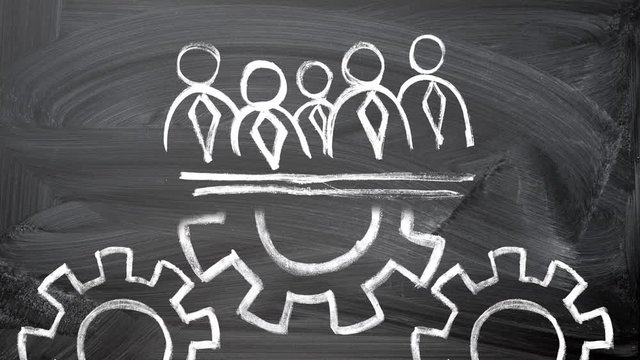 teamwork concept. chalk drawing on a blackboard of businessmen silhouettes and rotating gears below 