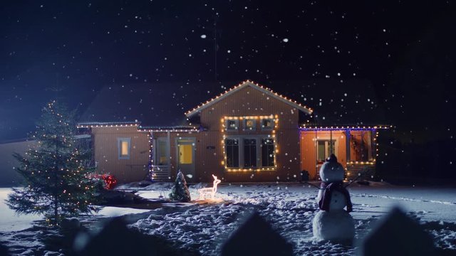 Idyllic House Decorated with Lights and Garlands for Christmas Eve. Front Yard Has Christmas Tree and Snowman. Soft Snow Falling Peacefully at Night. Shot on RED EPIC-W 8K Helium Cinema Camera.