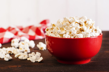 popcorn in a red bowl on a dark table