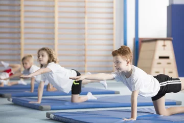 Fototapeten Children doing gymnastics © Photographee.eu