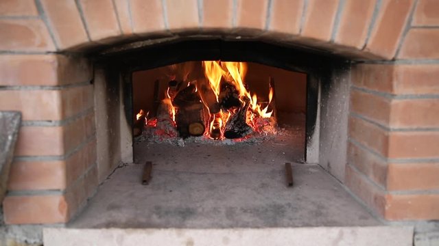 Legna che brucia in un forno a legna,  per cucinare pizza e pane