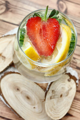 Detox flavored water with lemon, cucumber and  strawberry on white background with decoration. Healthy food concept.  Refreshing summer homemade cocktail. Copy space. No sharpen. 