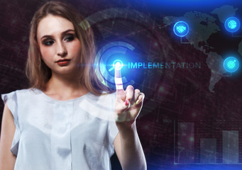 The concept of business, technology, the Internet and the network. A young entrepreneur working on a virtual screen of the future and sees the inscription: Implementation