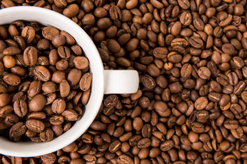 Coffee beans and white cup for coffee top view