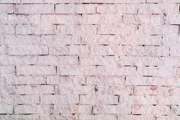 wall of bricks that are plastered pink, can be seen brickwork
