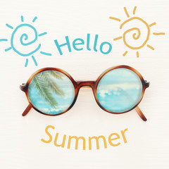 vacation and summer image with sunglasse over white wooden background. © tomertu
