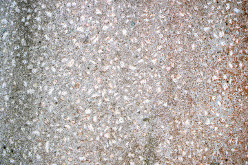 An old stone slab with small stones of granite, gray with time and rains