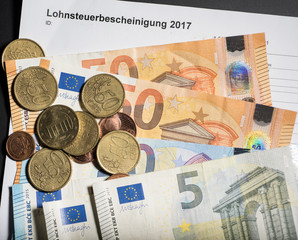 Lohnsteuerbescheinigung mit Münzen und Euroscheinen