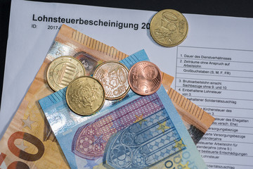 Lohnsteuerbescheinigung mit Münzen und Euroscheinen © Jürgen Hüls