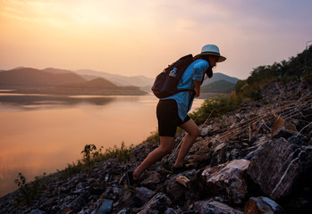 Obraz premium Beautiful female tourists are walking up a rocky hill above the lake.