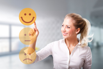 junge Frau wählt freudigen Smiley vor modernem Bürohintergrund 