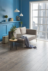 modern living room blue wall background and grey sofa. coffee table laptop in the city center.