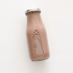 Top view image of chocolate milk over white wooden background. Symbols of jewish holiday - Shavuot.