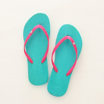 vacation and summer image with flipflops over white wooden background.