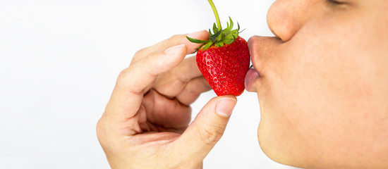 Man kissing strawberry and hand holding, white background