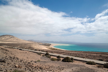 Beach and mountain landscape, turquoise sea, blue sky with clouds. Fuerteventura, Canary Islands.