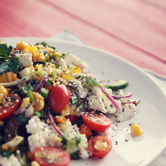 Colorful vegetable mix. Simple low calories salad. Cherry tomatoes, sweet corn, cucumber, bell pepper and cottage cheese. Weight loss dish. European cuisine. Toned photo.