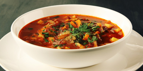 Tomato soup with red beans, potato and carrot. Vegan diet. European cuisine. Vegetarian dish. Main course. Organic meal. Side view. Wide photo.