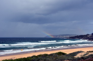 Rainbow over the Tasman sea. Seascape with beautiful multicoloured rainbow over the sea and Curl Curl beach, Australia.