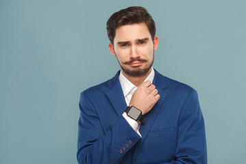 Portrait of unhappy business man wearing classic jaket, smart watch