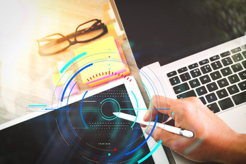 businessman working with digital tablet computer and memo note and laptop computer with digital business strategy layer effect on wooden desk as concept