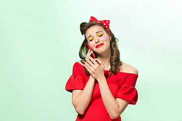 Beautiful young woman with pinup make-up and hairstyle. Studio shot on white background