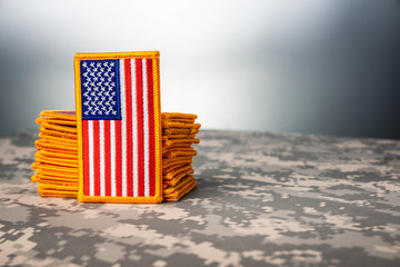 American flags stacked up sitting on camouflage
